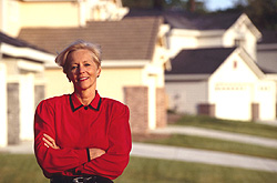 Homeowner association leader standing in front of a row of houses in her neighborhood.